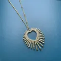 Close-up of a gold-plated heart sunburst pendant necklace sparkling with cubic zirconia stones. - Style C 30*35mm / 30*35mm