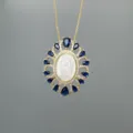 Closeup of gold-tone Guadalupe pendant necklace featuring mother-of-pearl and blue zirconia. - Style A Guadalupe