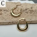 Classic chunky gold hoop earrings for women, minimalist polished metal statement jewelry piece. - Letter C