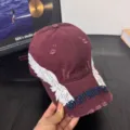 Detalle de gorra de béisbol burdeos desgastada, con alas bordadas blancas y texto frontal. - M / Burdeos