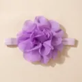 Close-up van de prachtige paarse chiffon bloem baby haarband details met zachte stoffen. - Paars