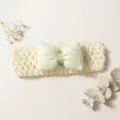 Close-up detail of the cute baby headband with green plaid bow and soft hollow knit. - Beige