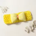 Detail shot of a yellow crochet baby headband featuring a cute checkered bow accent. - Yellow