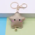 Close-up detail of the cute gold star PU leather keychain with a smiling face and bell. - Gold 8-shaped Clasp / Gold