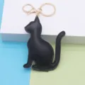 Detail view of the black PU leather cat keychain with golden hardware charm and key ring. - Cat / Black - Gold Chain Buckle
