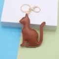 Close-up detail of the cute cat leather keychain with smooth PU surface and golden metal ring. - Cat / Coffee - Gold Chain Buckle