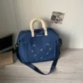 Borsa da viaggio blu scuro con ricamo di fiocchi graziosi, manici imbottiti e tracolla. - Blu