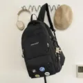 Sac à dos noir élégant sac d'école décontracté avec plusieurs poches et décor de badge tendance. - Sac à dos / Avec Pendentif / Noir