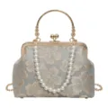 Close-up detail of the vintage kiss-lock handbag, featuring gold metal frame and pearl strap. - Golden Handle / Blue