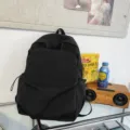 Minimalist black backpack for daily commuting, large capacity school bookbag for students. - Black