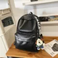 Casual black PU leather backpack for women, stylish dog pendant school book bag for daily use. - Pendant Style / Black