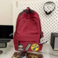 Red canvas casual backpack with cool letter patches and cute octopus keychain for daily use. - Red