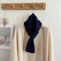 Detailed shot of a navy blue cable knit mini scarf draped gracefully for autumn and winter warmth. - Twist Cross Style / Navy Blue