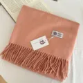 Close-up detail of the warm solid color thick wool scarf featuring elegant fringe design. - Dusky Pink