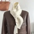 Vista dettagliata di una sciarpa incrociata in maglia crema su una giacca di pelle. - Bianco Latte