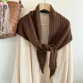 Detailed view of the brown wool knitted triangular scarf, cozy autumn style knitwear. - Coffee