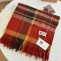 Gros plan détaillé d'un écharpe en laine à carreaux aux tons chauds rouge et orange. - Orange Citrouille
