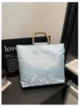 Detailaufnahme der blauen floralen Stofftasche mit natürlichem Bambusgriff und eleganter Textur. - Basisstil / Blau