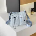 Hellblaue Nylon-Umhängetasche mit mehreren Fächern, Freizeittasche mit breitem Schulterriemen. - Blau