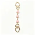 Gold metal bag charm with pink enamel heart pendants, stylish heart keychain accessory. - Pink