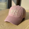 Close-up detail of the pink soft top baseball cap featuring delicate embroidered NYC letters. - Adult 54-60 Adjustable / Pink