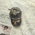 Detail van een retro camouflage baseballpet met geborduurde letters en versleten randdetails. - Verstelbaar / Camouflage Legergroen