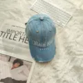 Gedetailleerd overzicht van een verwassen denim honkbalpet met witte borduursel in retro stijl. - Verstelbaar / Denim Blauw