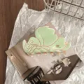 Close-up detail of green butterfly hair claw clip with pink trim, flat lay styling shot. - Light Green