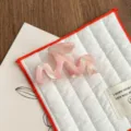 Detailed shot of a stylish pink acetate hair claw clip, featuring a wave design for elegant hairstyles. - Pink Stripe