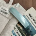Close-up of elegant curved light blue acetate hair barrette, premium daily styling detail. - Creamy Blue