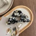 Detail view of the acetate hair claw clip featuring chic heart cutout and elegant pattern. - Ink Black