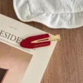 Red acetate duckbill hair clip featuring gold metal interior, stylish side hairpin detail. - Red