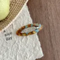 Detailed shot of Korean style oval acetate hair clip with blue tortoiseshell design. - Lake Blue Brown