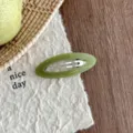 Detailed close-up of green acetate oval hollow hair clip, showcasing exquisite texture and design. - Grass Green