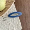 Detailed close-up of Korean style hollow oval acetate hair clip, elegant blue side clip. - Dark Blue