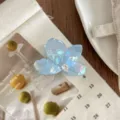 Detailansicht der schimmernden blauen Blumen-Haarklammer mit Strassakzent, elegantes Design. - S / Irisierendes Blaugrau