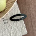 Korean style black oval acetate hair clip detail shot, elegant hollow design for women hair styling. - Black