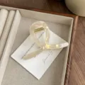 Detail view of the elegant iridescent hair claw clip featuring a unique abstract design. - Iridescent Yellow