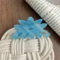 Closeup of blue acetate flower hair claw clip, elegant floral design for daily use. - Blue