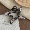 Detail shot of stylish hollow star hair claw clip with acetate tortoiseshell and pink accents. - Black Gold Powder