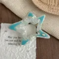 Close-up detail of a hollow star hair claw clip with blue and white marbled texture, stylish. - Blue & White