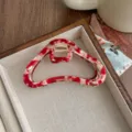 Primer plano de la pinza de pelo de nube de acetato rojo y blanco, diseño metálico elegante. - Rojo Blanco