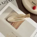 Close-up detail of the stylish acetate hair clip, elegant gold metal clip design. - Champagne