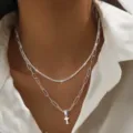 Stijlvolle dubbellaagse zilverkleurige ketting met fijne glitterketting en kruishanger. - 2456