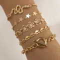 Set di bracciali multistrato dorati con motivi di serpente, stella, fiore e cuore. - Oro