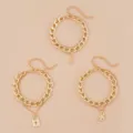 Dettagli in primo piano di bracciali a catena dorata multistrato con luna, lucchetto e farfalla. - Stile Luna