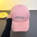 Pink baseball cap detail view, featuring stylish embroidered text and curved brim for sun protection. - One Size / Pink