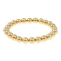 Vista dettagliata del bracciale elastico con perline rotonde dorate, elegante accessorio. - Oro