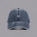 Close-up van gewassen denim honkbalpet met schattig wit hartborduurwerk en gebogen rand. - M (56-58cm) / Marineblauw