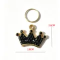 Detailed close-up of a sparkling black rhinestone crown pet pendant with gold split ring. - Black Crown